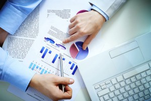 Close-up of female and male hands pointing at business document while discussing it